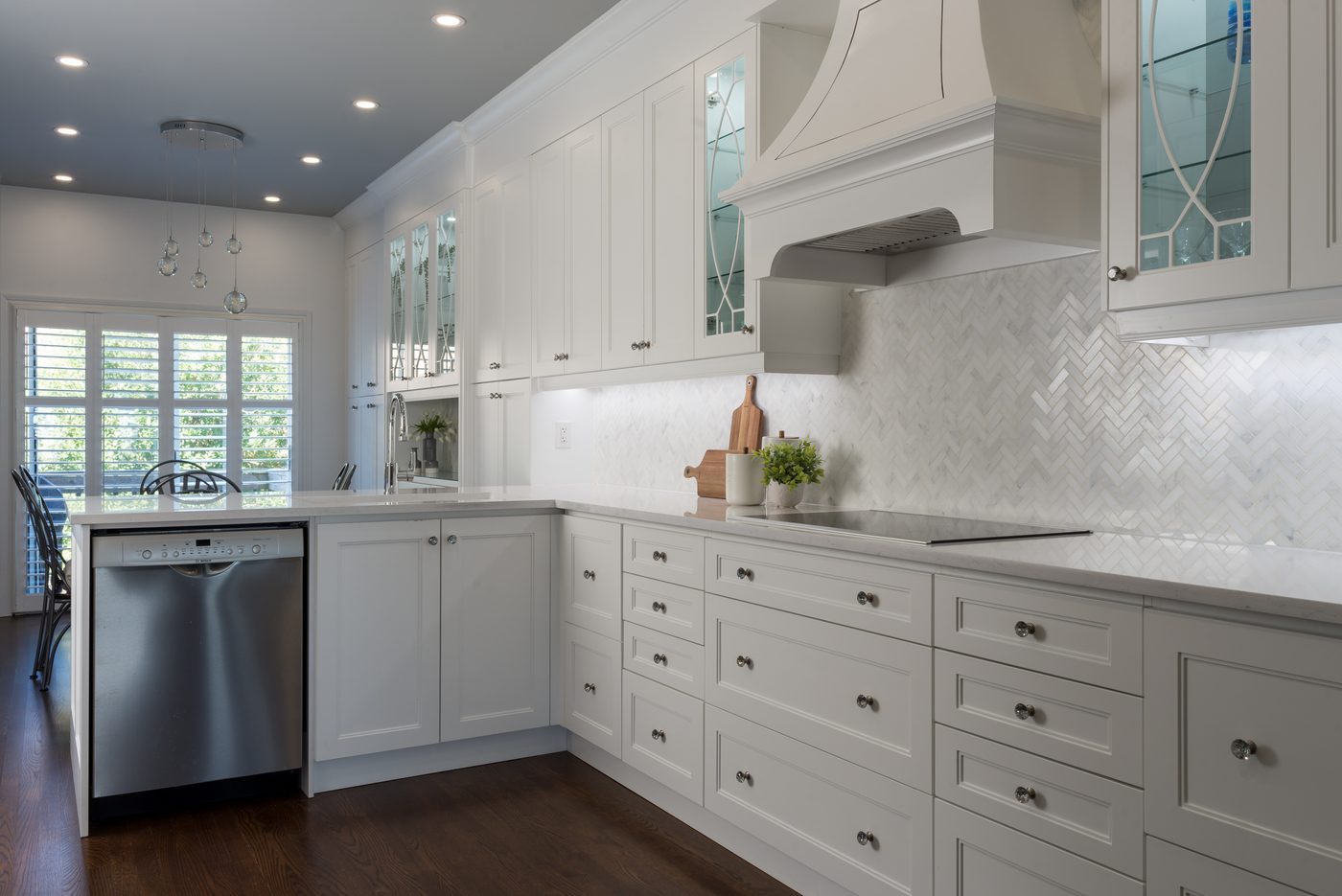 Renovated white kitchen with herringbone backsplash in a Toronto home