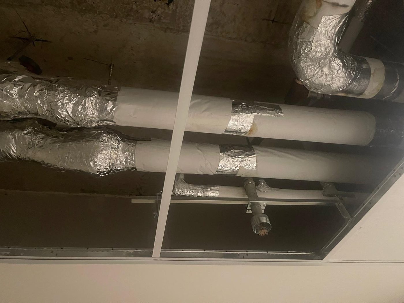 Foil-faced duct wrap insulation on basement HVAC ductwork in Toronto