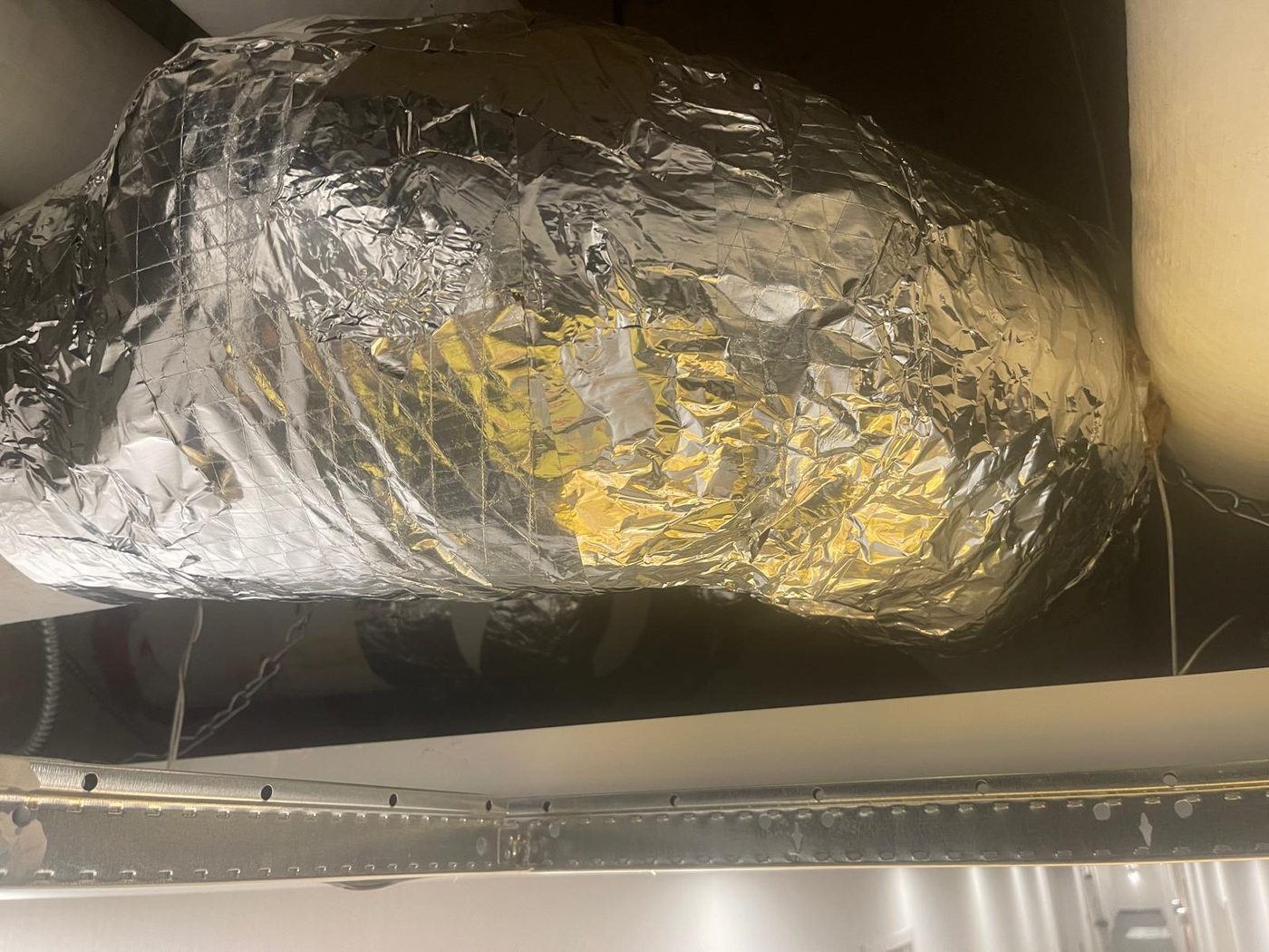 Insulated ductwork and pipe runs in a Toronto basement ceiling